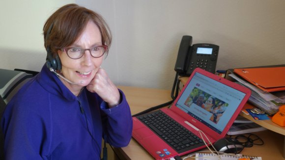 A helpline volunteer speaking via a headset