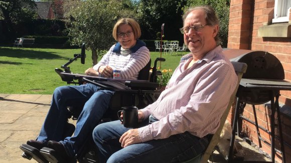 In the sunshine on their patio, Delia our blogger with her husband Nick, they smile to camera.