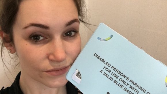 Jessie holding her blue badge