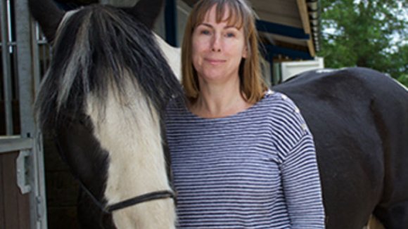 a photo of Sandy standing by her horse