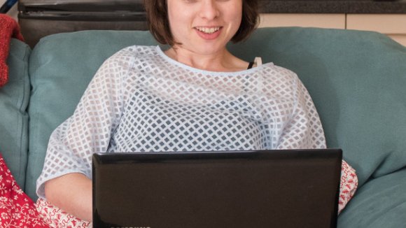 Edith on sofa using a laptop