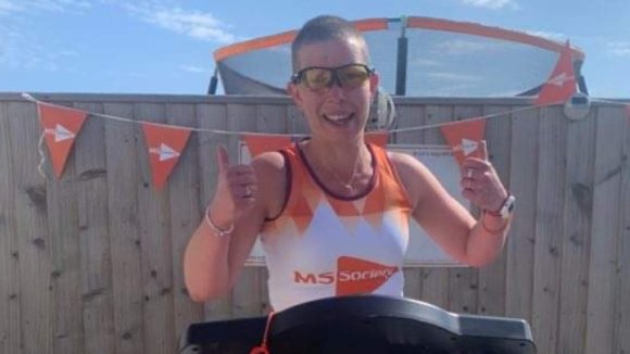 Angharad in MS Society t-shirt using a treadmill outside