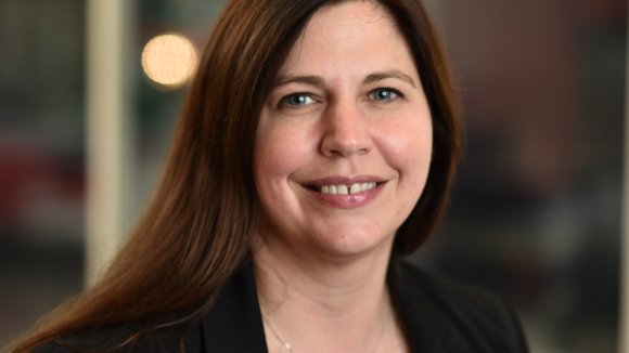 Head and shoulders portrait of Dr Sarah Rawlings facing the camera smiling