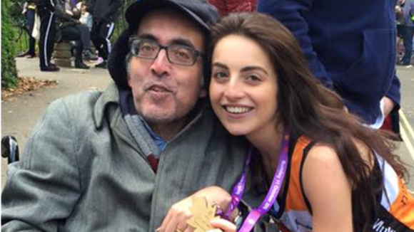 Photo shows Emily dressed MS Society running gear and wearing a medal posing with her dad.