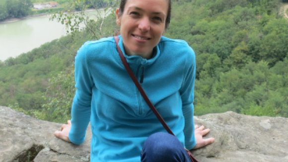 Sarah Rees sitting outside on a rock