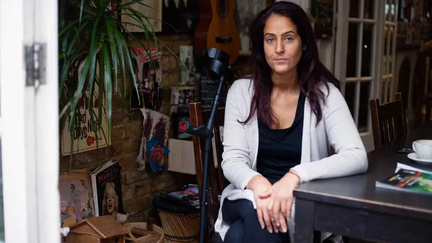 Image shows a woman sat at home concerned about her MS diagnosis