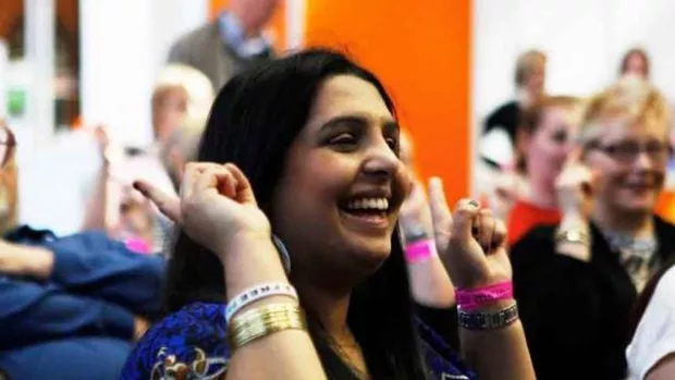 Woman with hands up at MS Society meeting