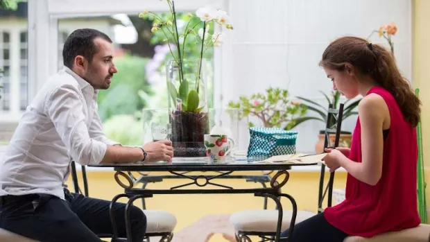 Photo: Two people sat at a table in a conservatory