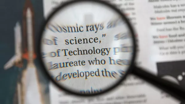a graphic showng a newspaper through a magnifying glass 