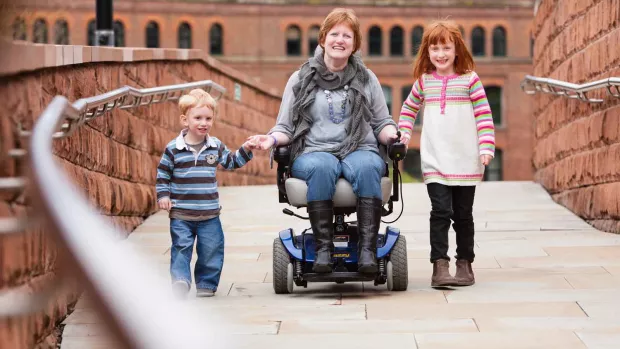 Photo: woman with MS in wheelchair with young children