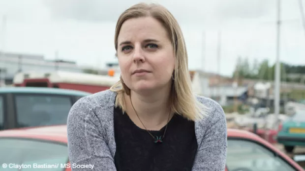 A woman with blond hair wearing a grey cardigan