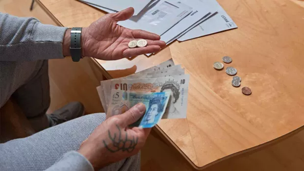 Photo: Man counting money and looking at bills close up