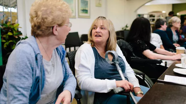 Photo: Two women at an MS group talk to each other