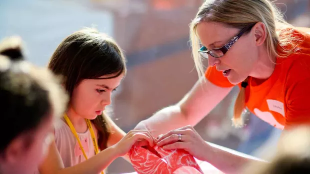 Photo: an MS fundraiser helping a child with a craft project