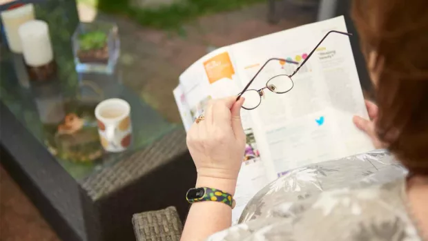 Photo: A woman reading MS matters in the garden