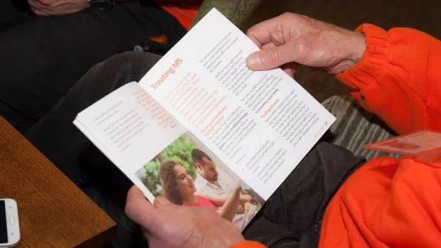 Photo of Hands holding a  MS information booklet