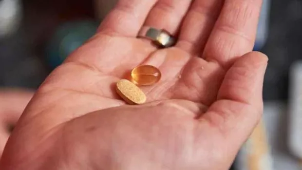 A person holding some pills to demonstrate drugs and medicine as a type of MS treatment