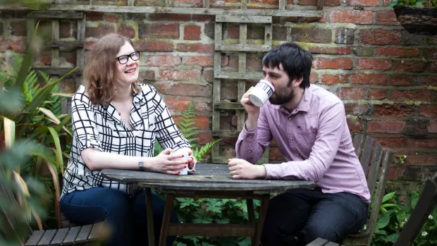 Photo: a couple in their garden drinking tea