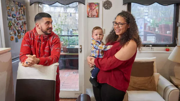Photo: a couple with a baby standing in a dining room