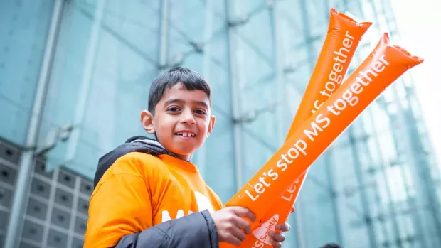 A boy holding two inflatable clappers