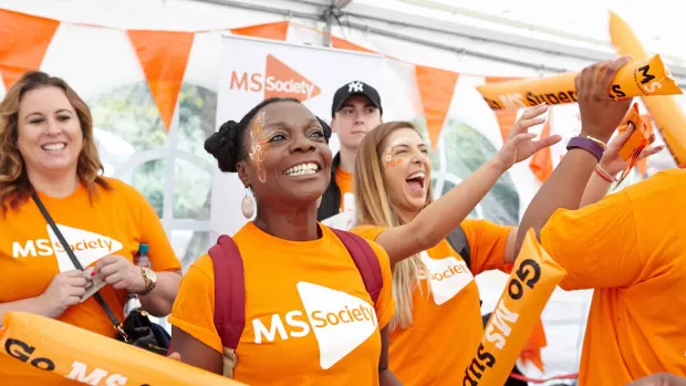 Photo: a group of MS fundraisers cheering with smiling faces