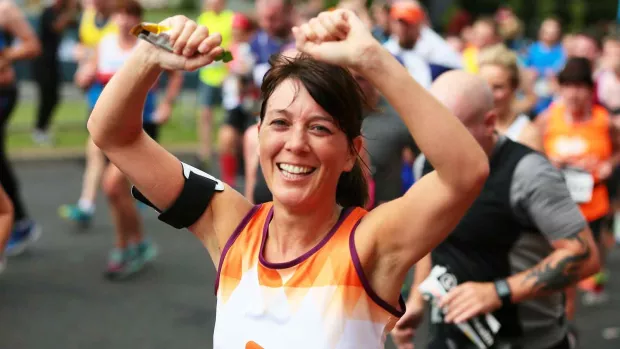 Image shows a woman running in an MS Society running vest