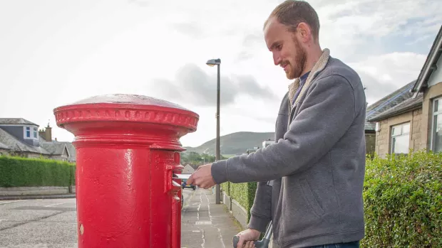 Photo: a man posting a letter