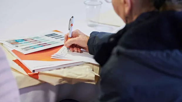 a photo a person writing on some forms