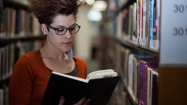 Photo: Woman with MS reading in the library