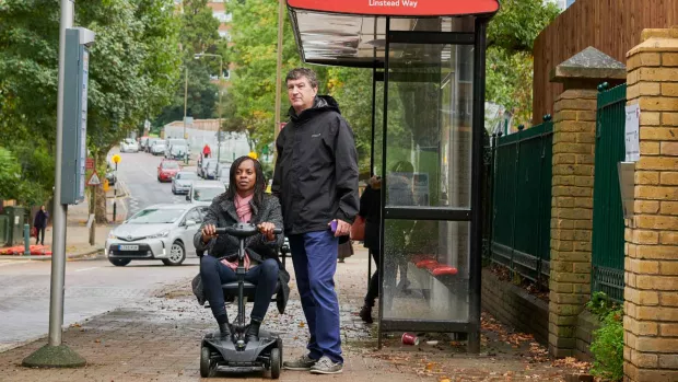 A photo of a woman with ms waiting for bus