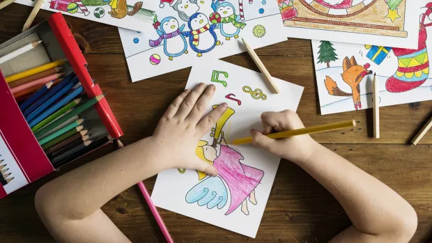 a photo of a Childs hands drawing a picture