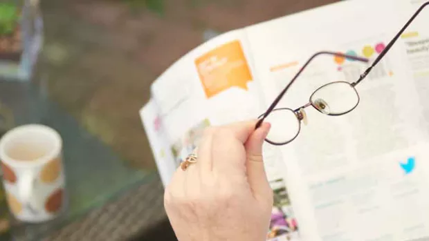 lady with ms putting on her glasses to help with eye pain and vision problems