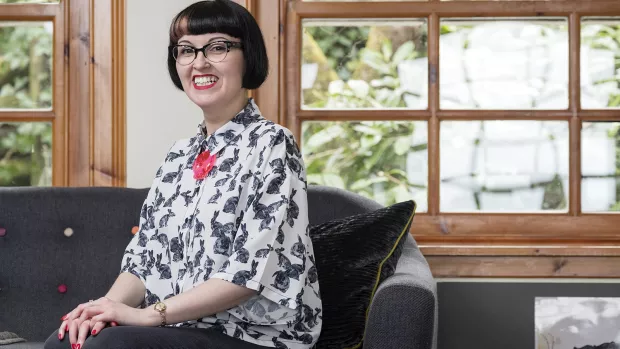 PhotoPhoto: Kirsty sitting on sofa by window smiling to camera