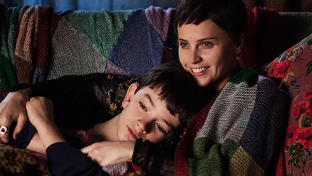 Boy and mother cuddling on sofa