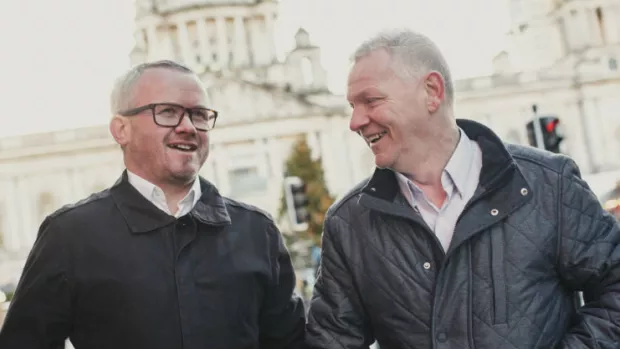 Two men chatting as they walk down the street in Belfast