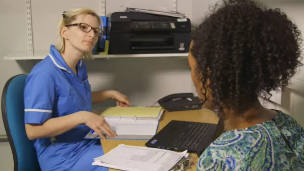 Photo: a woman in an appointment with a nurse