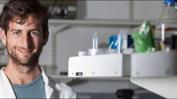 Photo: Researcher working in the lab and smiling at the camera