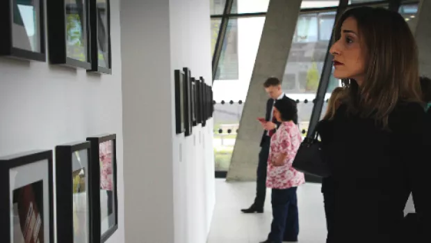 A woman looking at pictures at an exhibiton