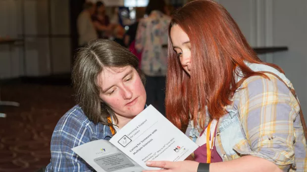 two women reading an MS support leaflet