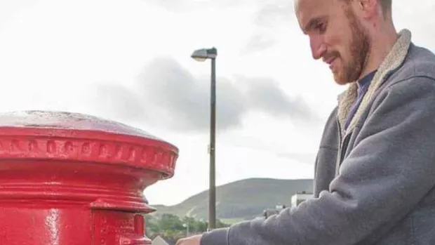 Man dropping off used postage stamps for recycling