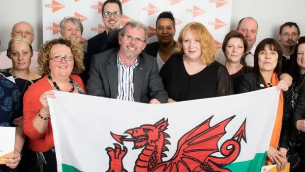 A group of people in Wales holding a Welsh flag