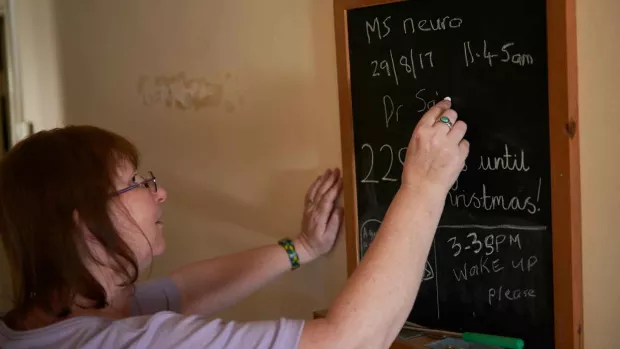 Photo: a Woman writing a MS neuro appointment