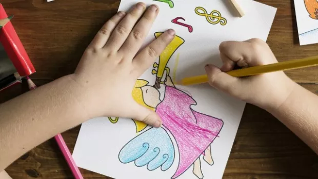 Child colouring a picture and being happy in their life, demonstrating the importance of explaining MS to children