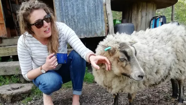 Claire outside next to a sheep