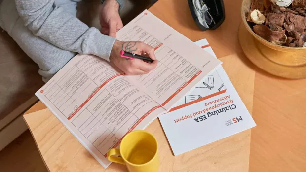 Photo: Person filling in Employment and support allowance application forms