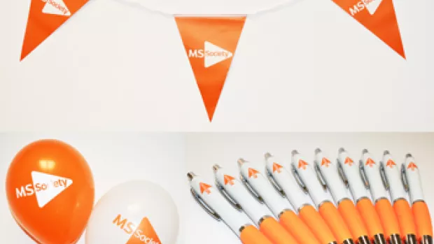 a photo of a MS celebration party pack with orange bunting, balloons and pens
