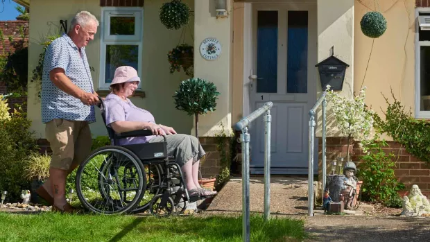Photo: Man pushing his wife in wheelchair