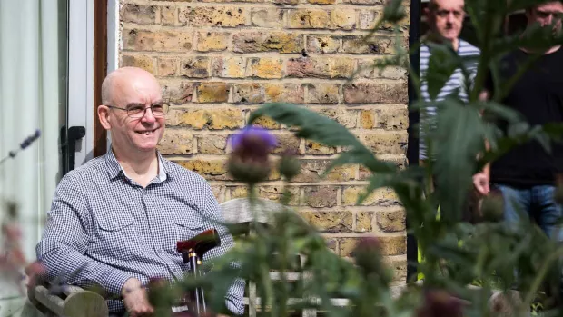 Man smiling on garden bench