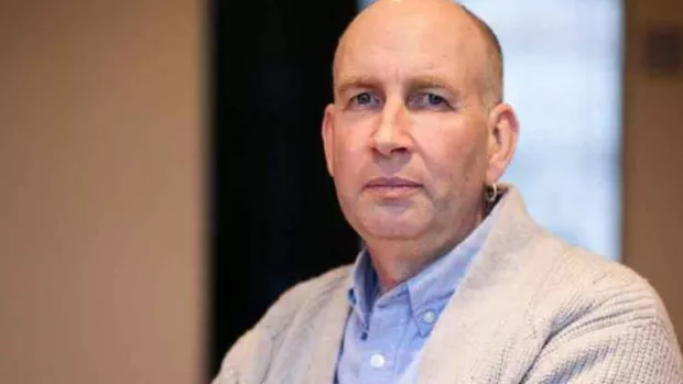 Image show a man with MS at home looking sad