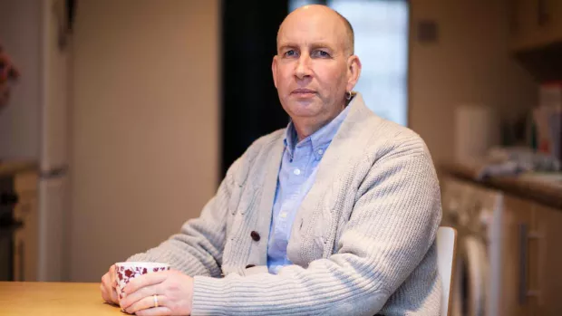 Image show a man with MS at home looking sad